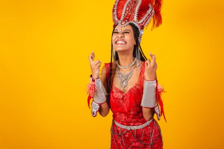 Foto de Hermosa mujer brasileña negra, con ropa roja de carnaval. dedos cruzados, suerte, deseo - Imagen libre de derechos