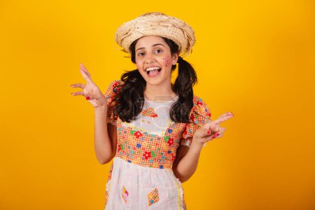Téléchargez les photos : Belle femme brésilienne, avec des vêtements de fête de juin, doigts croisés, souhaitant dur, acclamant. - en image libre de droit
