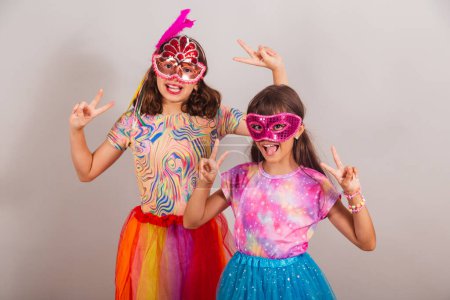 Foto de Dos niños brasileños, niñas, vestidas con traje de carnaval, pose de paz y amor. - Imagen libre de derechos