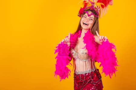 Foto de Hermosa mujer brasileña rubia con ropa de reina de la escuela de samba, carnaval. Corona de plumas. bailando y fiesteando. - Imagen libre de derechos