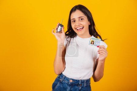 Photo for Beautiful brazilian woman holding car key and driving document. - Royalty Free Image