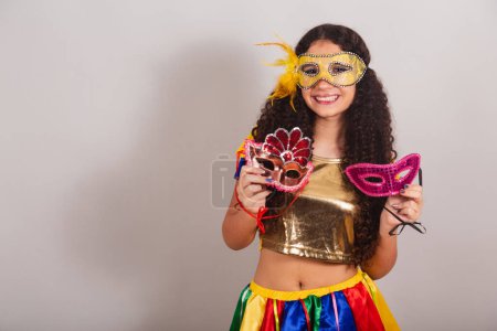 Photo for Young teen girl, brazilian, with frevo clothes, carnival. holding carnival masks. - Royalty Free Image
