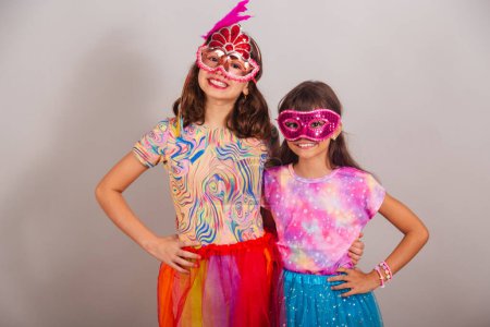 Foto de Dos niños brasileños, niñas, vestidos con ropas de carnaval, abrazando y sonriendo a la cámara. - Imagen libre de derechos