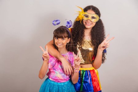Foto de Dos amigas brasileñas, vestidas con ropa de carnaval. abrazados, posando jugando juntos. - Imagen libre de derechos