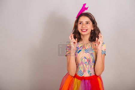 Téléchargez les photos : Enfant brésilien, fille, habillée en tenue de carnaval, signe de chance avec les doigts, acclamation, souhait. - en image libre de droit