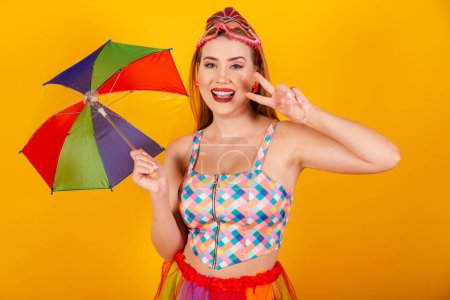 Photo for Brazilian redhead, in carnival clothes, with a colorful parasol. peace and love. - Royalty Free Image
