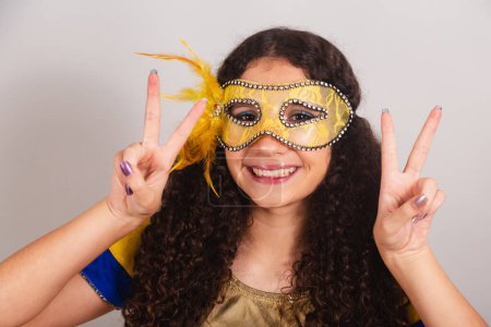 Téléchargez les photos : Jeune adolescente, brésilienne, avec des vêtements frevo, carnaval. masque, gros plan photo paix et amour. - en image libre de droit