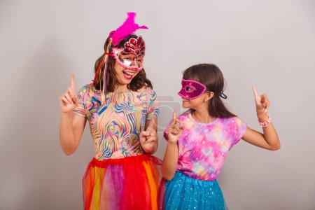 Photo for Two Brazilian children, girls, dressed in carnival clothes, dancing. - Royalty Free Image
