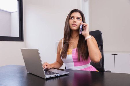 Photo for Beautiful caucasian brazilian business woman working in office, notebook. talking on the cell phone - Royalty Free Image