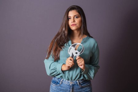 Photo for Horizontal photo. Beautiful Brazilian woman, with casual clothes, Jeans and green shirt. nutritionist holding adipometer. - Royalty Free Image