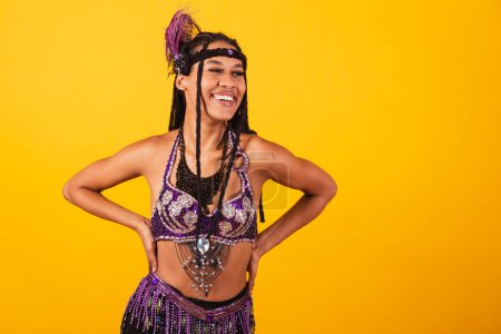Téléchargez les photos : Belle brésilienne noire, vêtue de carnaval violet, les mains sur les hanches. - en image libre de droit