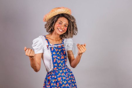 Photo for Young black Brazilian woman, with country clothes, dressed for Festa Junina. Saint John's festival. inviting hands. - Royalty Free Image
