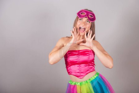 Téléchargez les photos : Femme blonde brésilienne vêtue de vêtements de carnaval rose. port de mascara, cris de promotion, publicité. - en image libre de droit