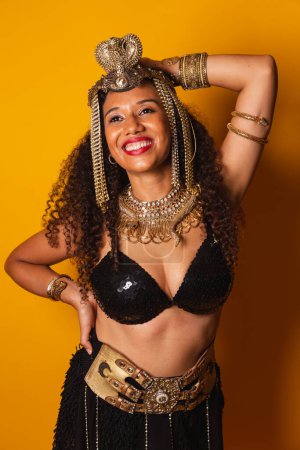 Foto de Vertical, tiro de medio cuerpo de hermosa mujer brasileña negra en ropa de carnaval. manos en la cintura. - Imagen libre de derechos