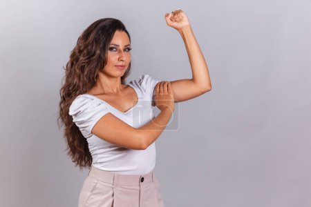 Photo for Beautiful Brazilian woman, brown hair, high clenched fist, empowered. - Royalty Free Image