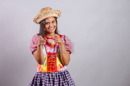 Foto de Mujer brasileña vistiendo ropa de campo, fiesta So Joo, fiesta Junina. apuntando a la cámara, eligiéndote. - Imagen libre de derechos