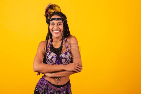 Foto de Hermosa mujer brasileña negra, con ropa de carnaval púrpura, brazos cruzados. - Imagen libre de derechos