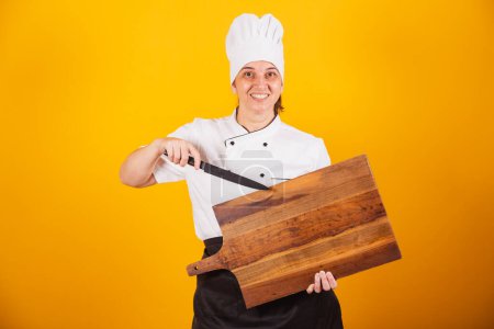 Téléchargez les photos : Femme brésilienne adulte, chef, maître en gastronomie. tenant planche à découper et couteau en bois. - en image libre de droit