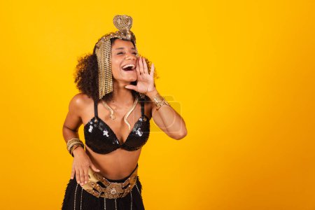 Photo for Beautiful black Brazilian woman, in Cleopatra carnival clothes, shouting promotion, advertising. - Royalty Free Image
