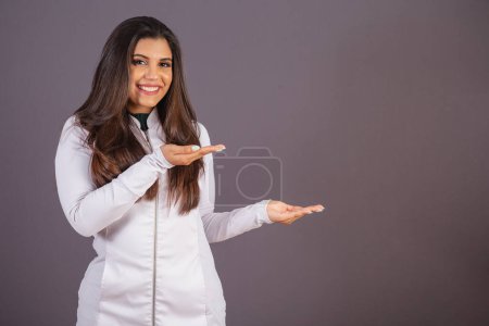 Téléchargez les photos : Photo horizontale. femme brésilienne avec manteau médical, nutritionniste. publicité à droite. - en image libre de droit