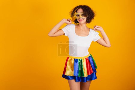 Photo for Beautiful Brazilian woman, dressed in carnival clothes, colorful skirt and white shirt. wearing mascara, dancing. - Royalty Free Image