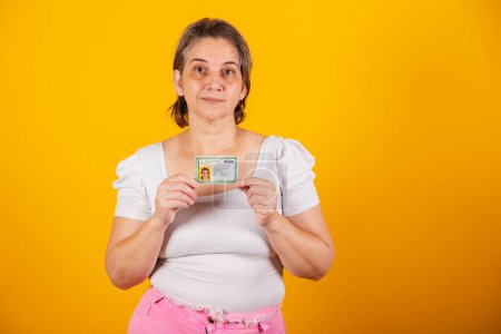 Photo for Adult Brazilian woman holding identity card, RG - Royalty Free Image