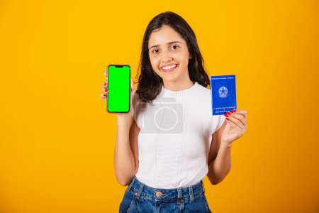 Téléchargez les photos : Belle femme brésilienne tenant carte de travail et téléphone portable avec écran vert. - en image libre de droit