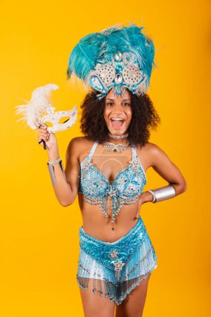 Foto de Mujer negra reina de la escuela brasileña de samba, con ropa de carnaval azul y corona de plumas. máscara de retención. - Imagen libre de derechos