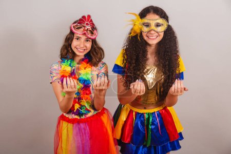 Foto de Chicas brasileñas amigas, vestidas con ropas de carnaval. invitando a las manos. - Imagen libre de derechos