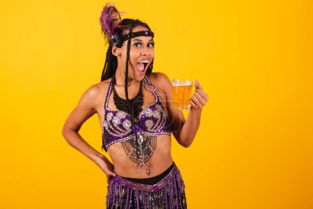 Téléchargez les photos : Belle femme brésilienne en violet vêtements de carnaval boire de la bière. - en image libre de droit
