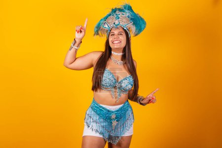 Photo for Beautiful brazilian woman with blue carnival clothes, feather crown, carnival queen, dancing - Royalty Free Image