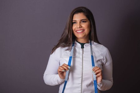 Foto de Foto horizontal. mujer brasileña con abrigo médico, nutricionista. cinta métrica. adelgazar. - Imagen libre de derechos