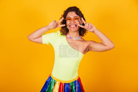 Photo for Beautiful afro american brazilian woman in carnival clothes making peace and love sign. - Royalty Free Image