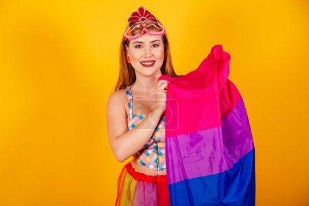 Foto de Pelirroja brasileña, vestida de carnaval, con una bandera bisexual, lgbt. - Imagen libre de derechos