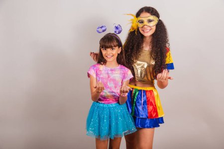 Téléchargez les photos : Deux amies brésiliennes, vêtues de vêtements de carnaval. invitant les mains. - en image libre de droit