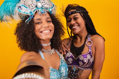Foto de Dos amigos brasileños en ropas de carnaval, tomando autorretrato con smartphone. - Imagen libre de derechos