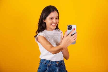 Foto de Hermosa mujer brasileña sosteniendo teléfono inteligente, tomando autorretrato, selfie. - Imagen libre de derechos