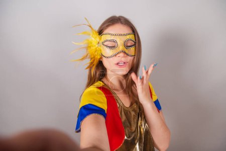 Téléchargez les photos : Femme blonde brésilienne, vêtue de vêtements frevo, masque de carnaval, prendre selfie. - en image libre de droit