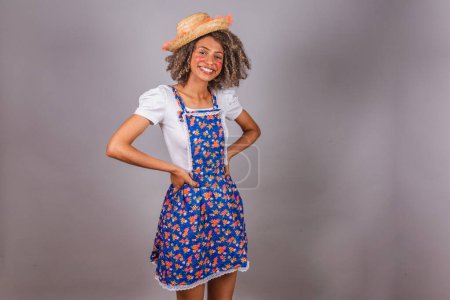 Photo for Young black Brazilian woman, with country clothes, dressed for Festa Junina. Saint John's festival. Hands on hips. - Royalty Free Image