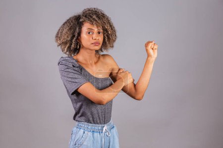 Photo for Black Brazilian woman, beautiful, fist clenched, posing for photos. militancy, female resistance, empowerment. - Royalty Free Image