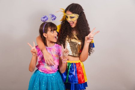Foto de Dos amigas brasileñas, vestidas con ropa de carnaval. abrazados, posando jugando juntos. - Imagen libre de derechos