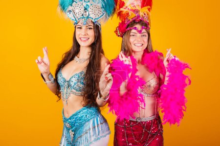 Photo for Two brazilian female friends with queen clothes from samba school, carnival. Feather crown. dancing and partying - Royalty Free Image