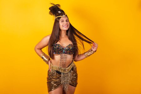Téléchargez les photos : Belle femme brésilienne en vêtements de carnaval d'or, tenant les cheveux. - en image libre de droit