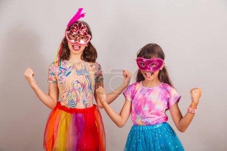 Téléchargez les photos : Deux enfants brésiliens, filles, vêtus de vêtements de carnaval, célébrant. - en image libre de droit
