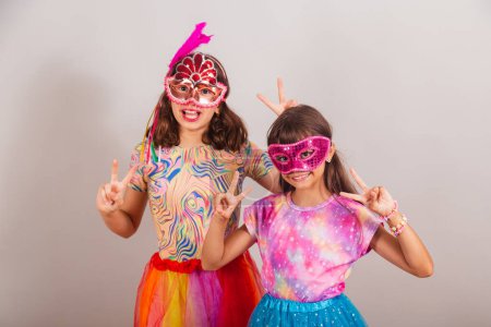 Photo for Two brazilian children, girls, dressed in carnival outfit, peace and love pose. - Royalty Free Image