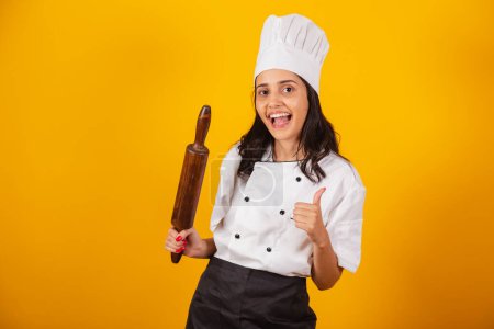 Photo for Brazilian woman, head chef, cook, holding wooden rolling pin. - Royalty Free Image