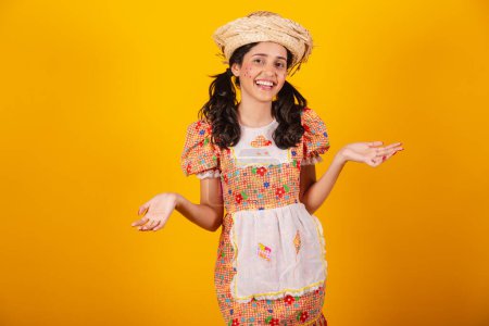 Foto de Hermosa brasileña, con ropa de fiesta de junio, riendo, con los brazos abiertos, bienvenida. - Imagen libre de derechos
