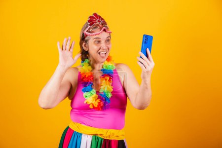 Téléchargez les photos : Femme adulte en vêtements de carnaval, souriant à la caméra, prenant autoportrait avec smartphone. - en image libre de droit