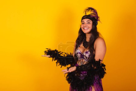 Photo for Brazilian woman, wearing carnival clothes, presenting something to the right. - Royalty Free Image