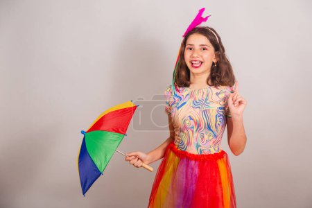 Foto de Niña brasileña, niña, vestida con traje de carnaval, bailando con paraguas frevo. - Imagen libre de derechos